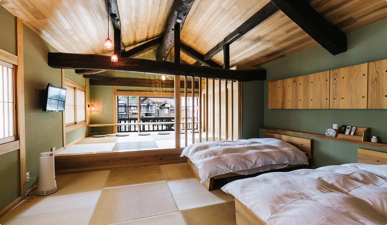 Interior of a renovated boathouse stay in Ine, featuring a tatami-style room with views of the seaside town.