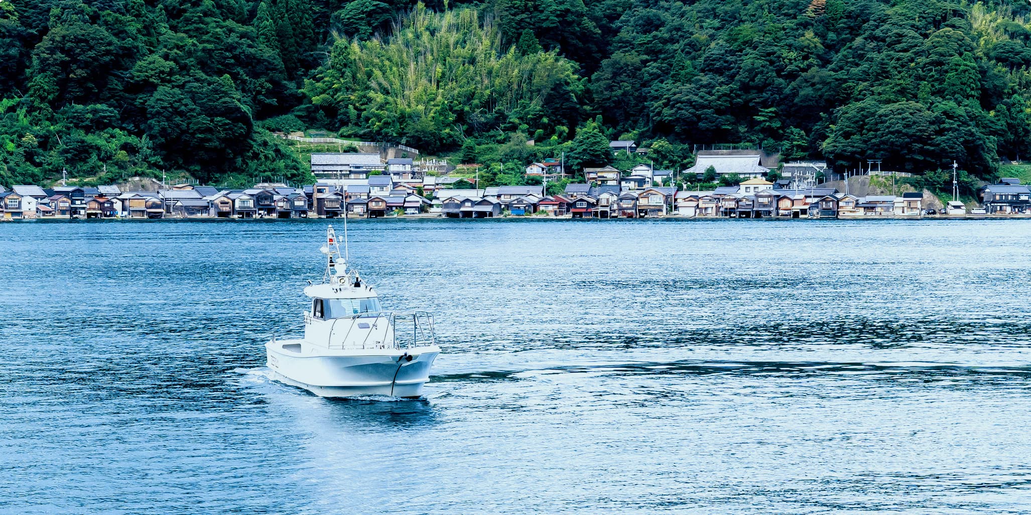 穏やかな伊根湾に浮かぶ漁船の風景
